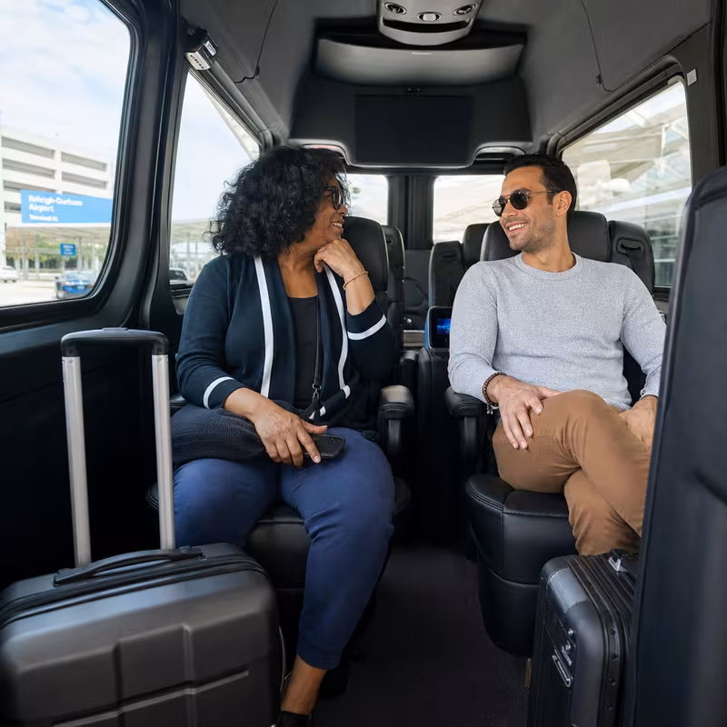 Passengers loading luggage while boarding an Raleigh group shuttle