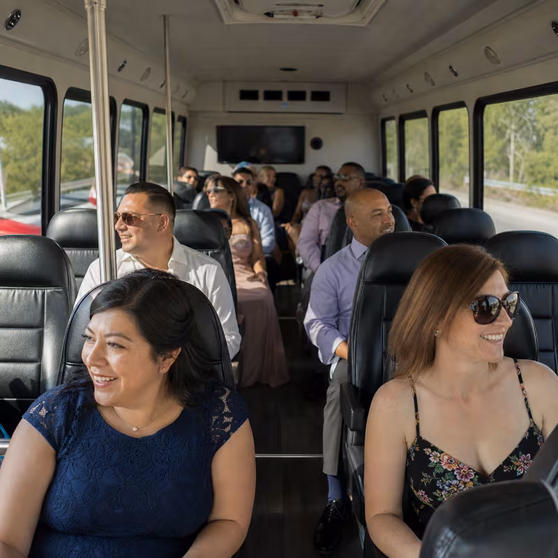 Group boarding a white charter bus for Private Event Transportation transportation in Raleigh