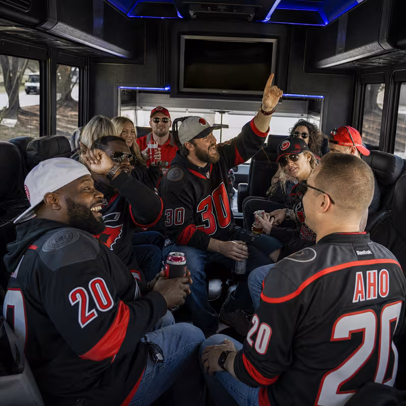 Group boarding a white charter bus for Sporting Event Transportation transportation in Raleigh